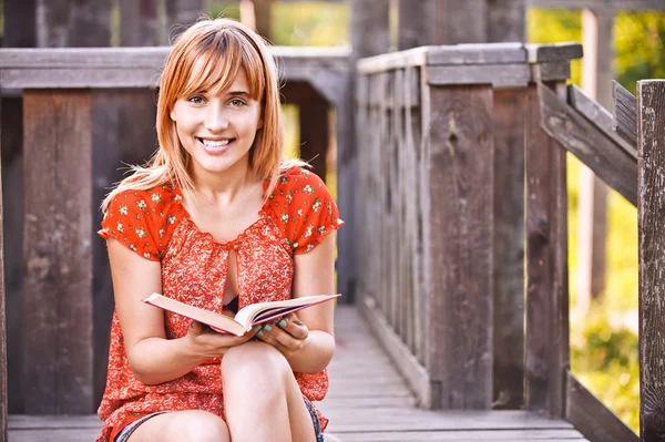 Νεαρή γυναίκα χαμογελώντας με το βιβλίο — Φωτογραφία Αρχείου