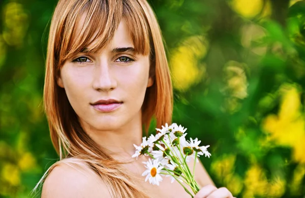 Retrato mujer joven sosteniendo ramo de manzanillas — Foto de Stock