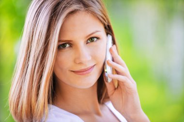 Portrait of young beautiful woman speaking on phone clipart