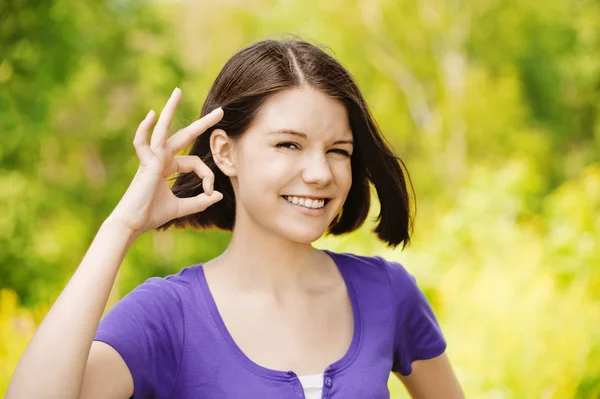 Portrait of young woman showing "ok" sign — Stock Photo, Image