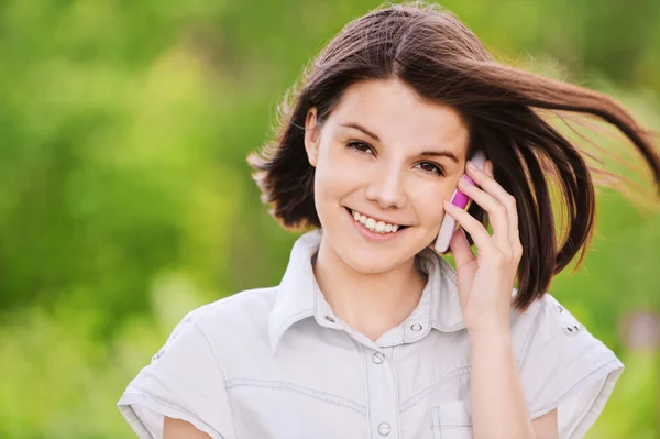 Portrait of young woman speaking on mobile — Stock Photo, Image