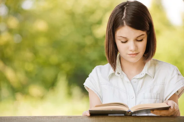 Retrato de bela leitura menina morena — Fotografia de Stock