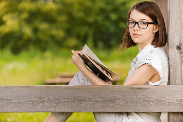 Portrait of young witty woman with book — Stock Photo, Image