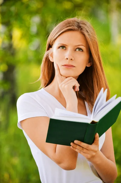 Young thoughtful woman holding book — Stock Photo, Image