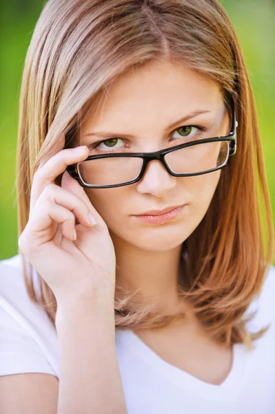 Porträt einer strengen Frau, die über ihre Brille blickt — Stockfoto