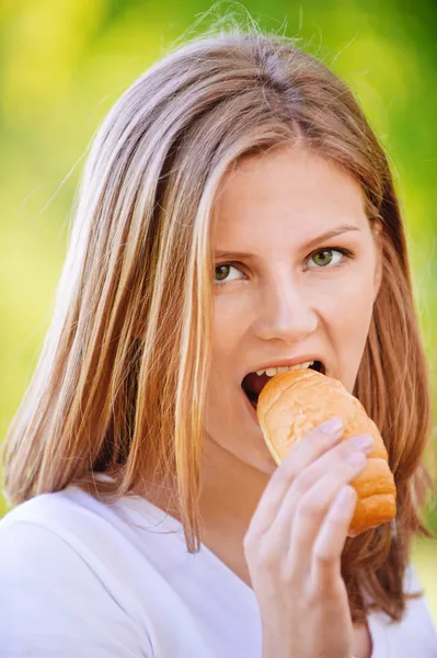 Portret van een jonge vrouw eten broodje — Stockfoto