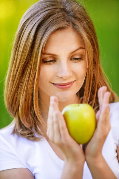 Retrato de mujer joven contenida sosteniendo manzana —  Fotos de Stock