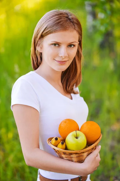 Ritratto di donna che tiene il cesto con frutta — Foto Stock