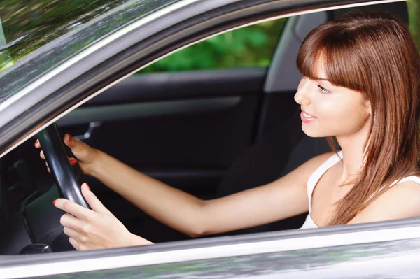 Portret van jonge lachende vrouw rijden auto — Stockfoto