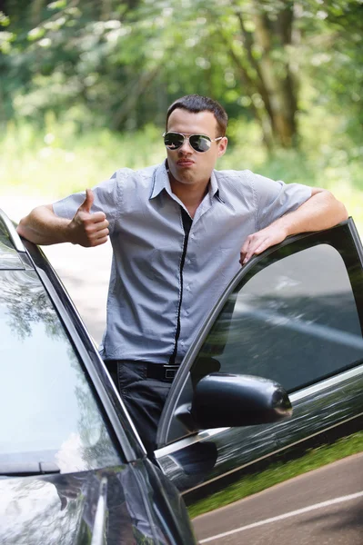 Junger Mann steht neben Auto — Stockfoto