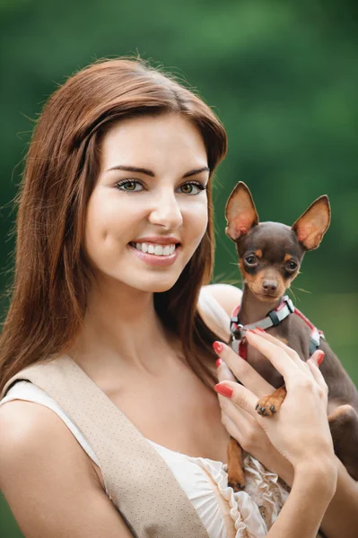 若い笑みを浮かべて女性持株犬の肖像画 — ストック写真