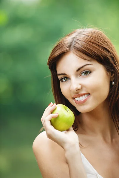 Mulher sorridente bonita segurando maçã verde — Fotografia de Stock
