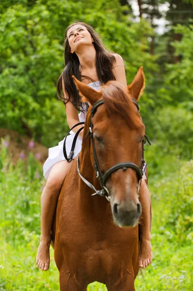 Молода усміхнена жінка верхи на коні — стокове фото