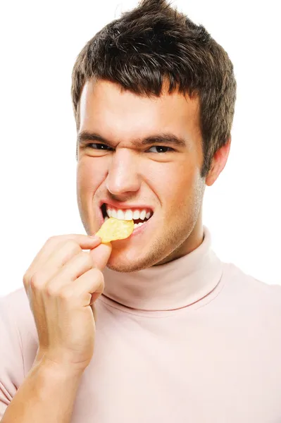 Portrait of young man eating chips — Stock Photo, Image