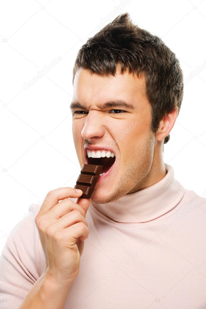 Portrait of young man eating chocolate