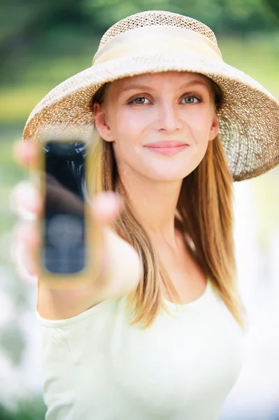 Gazdaság telefon Szalmakalapot viselő fiatal nő portréja — Stock Fotó