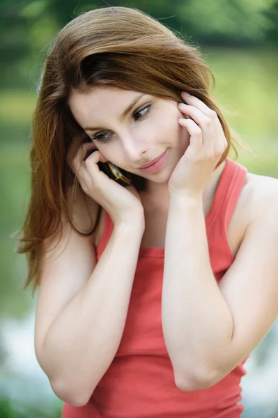 Retrato de uma jovem mulher falando por telefone móvel — Fotografia de Stock