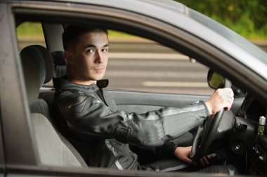 Portrait of handsome young man driving car clipart