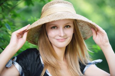 Portrait of young woman wearing straw hat clipart