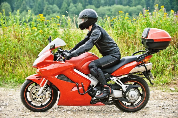 Motocyklista řízení proti poklidné scenérie — Stock fotografie