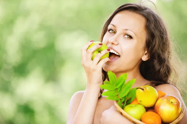 Portrait of young attractive brunette woman eating apple — Stock Photo, Image