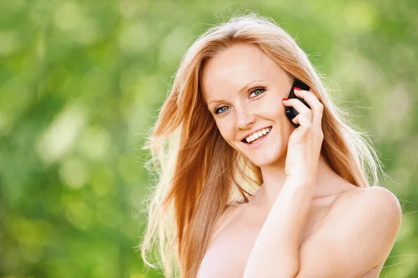 Портрет молодой веселой женщины, говорящей по телефону — стоковое фото