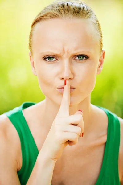 Retrato de mulher bonita segurando o dedo perto de sua boca — Fotografia de Stock