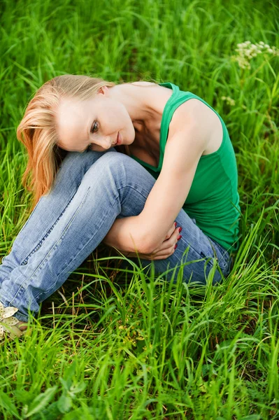 Портрет молодой красивой женщины, сидящей на траве — стоковое фото