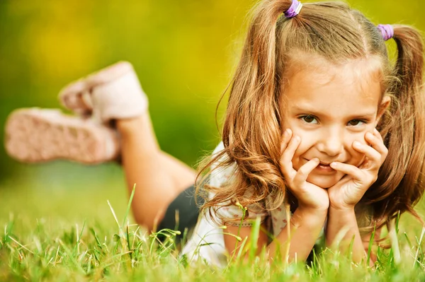草に横たわっている愛らしい少女の肖像画 — ストック写真