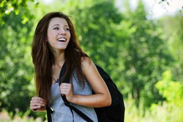 Ganska skrattande flicka klädd i ryggsäck — Stockfoto