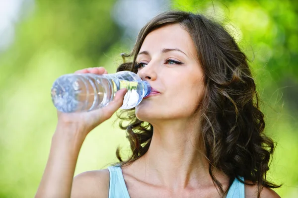 Giovane donna dai capelli scuri che beve acqua — Foto Stock