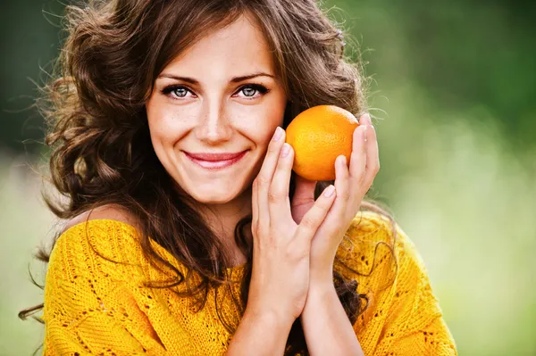Красивая женщина держит оранжевый — стоковое фото
