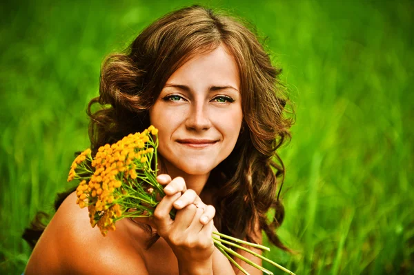 Portret van mooie vrouw met bouqet van gele bloemen — Stockfoto