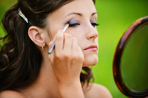 Młoda kobieta zabarwienie jej powieki — Zdjęcie stockowe