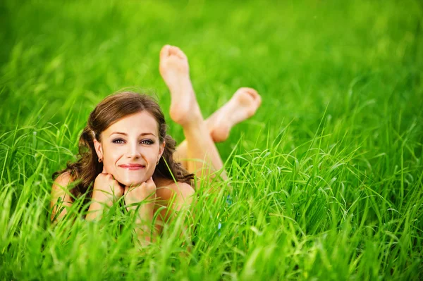 Genç bir kadın çimenlerde yatıyor. — Stok fotoğraf