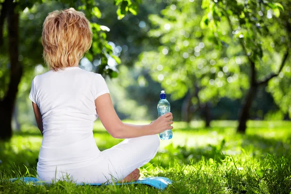 A woman in a park in the lotus position — Stock Photo, Image