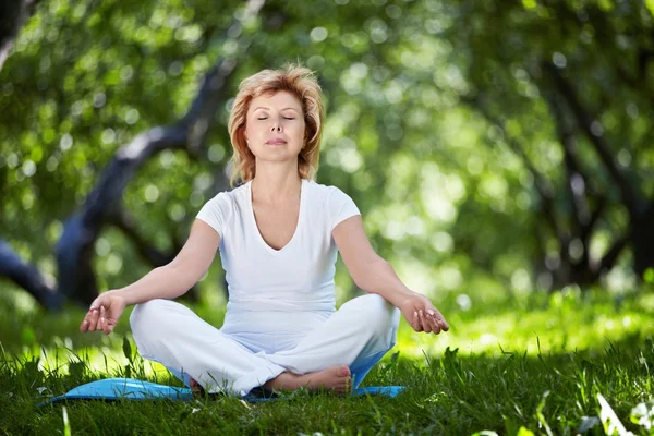 Reife Frau praktiziert Yoga — Stockfoto