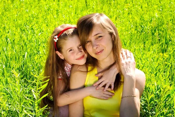 Lächelnde junge Mutter mit kleiner Tochter — Stockfoto