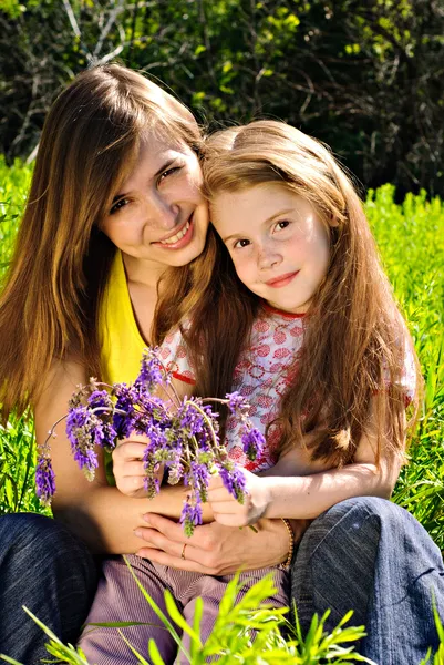 Lachende jonge moeder met kleine dochter — Stockfoto