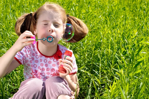 Маленька дівчинка дме бульбашки — стокове фото