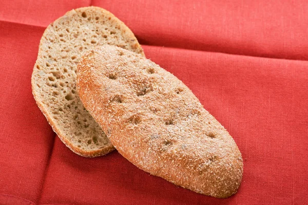 Black bread on red close up — Stock Photo, Image
