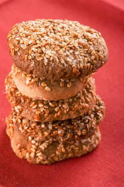 Kekse mit Sesamsamen auf rotem Makro — Stockfoto