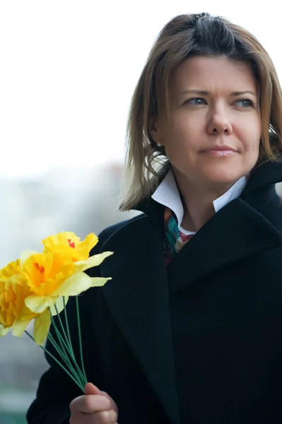 Vrouw in de straat met gele bloemen — Stockfoto