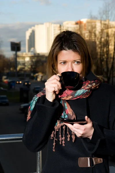 Žena na ulici s šálkem kávy — Stock fotografie