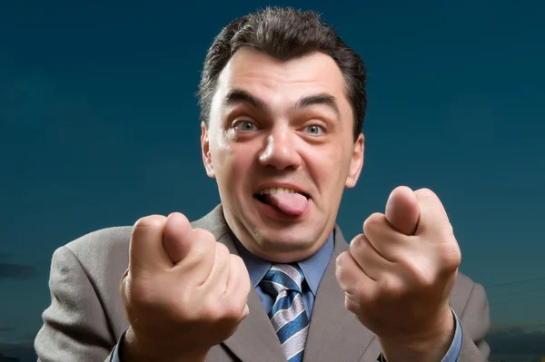 Muž v obleku ukazuje jazykem zblízka — Stock fotografie