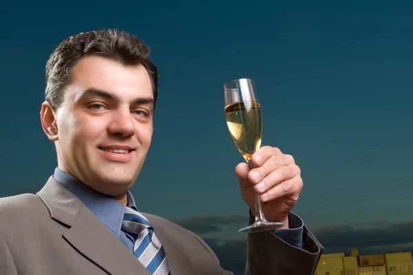 Man in pak met een glas champagne — Stockfoto