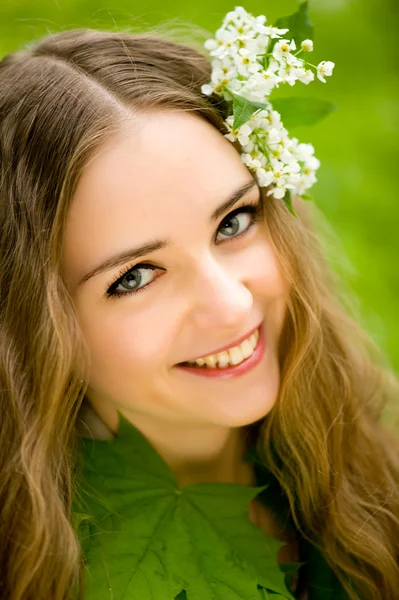 Flicka med blommor i sitt hår makro — Stockfoto