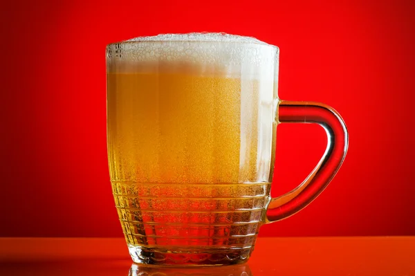 Пиво на красном фоне — стоковое фото