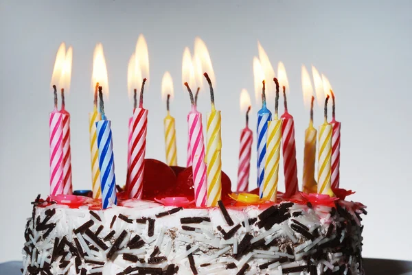 Um bolo de aniversário com velas acesas — Fotografia de Stock