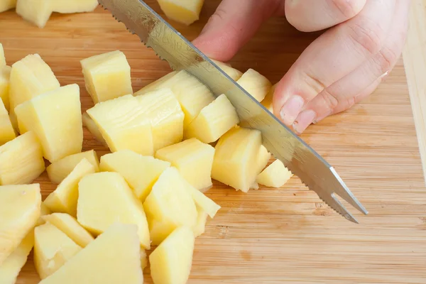 Las manos femeninas cortar patatas — Foto de Stock